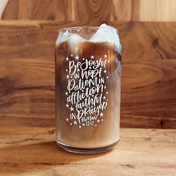 Glass of iced coffee with a quote on a wooden surface