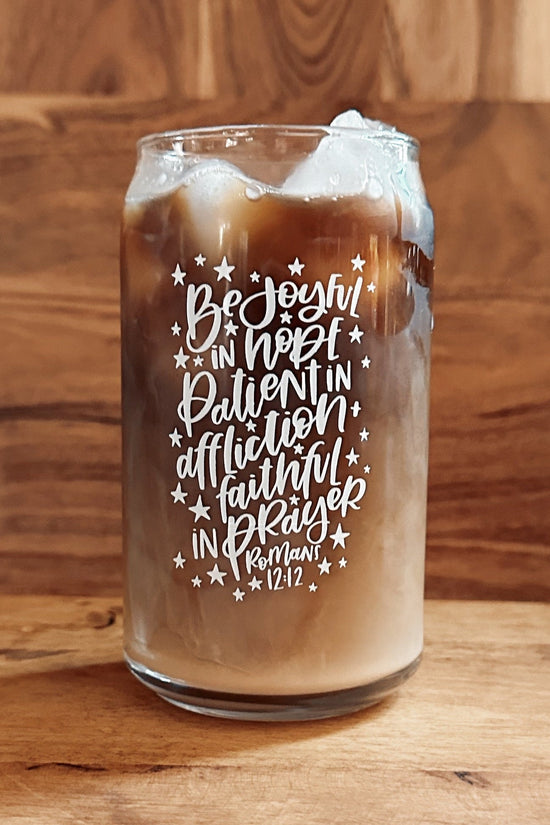 Glass of iced coffee with a quote on a wooden surface